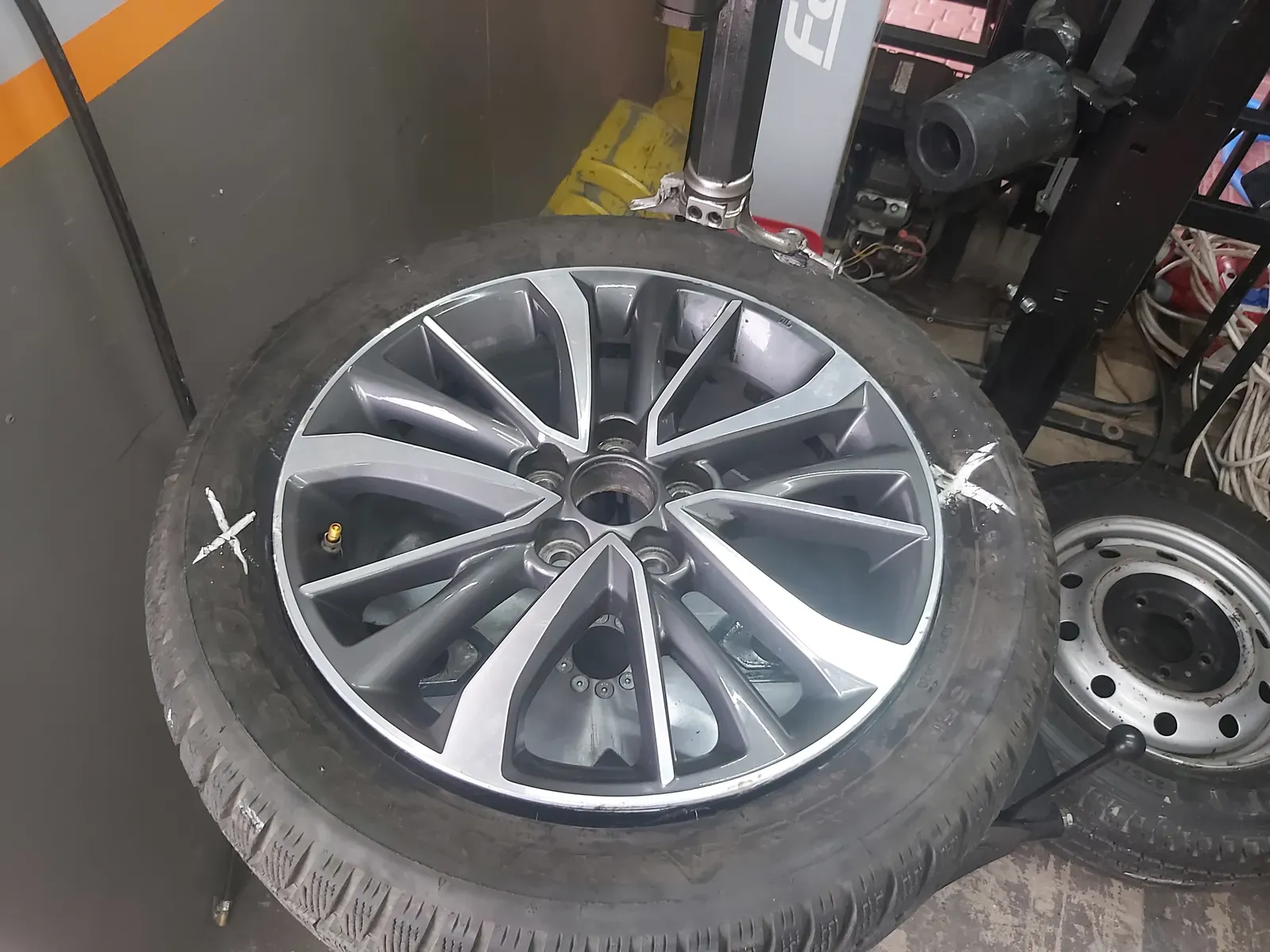 Koło z felgą aluminiową zamocowane na montażownicy w warsztacie KB Mobile Garage
