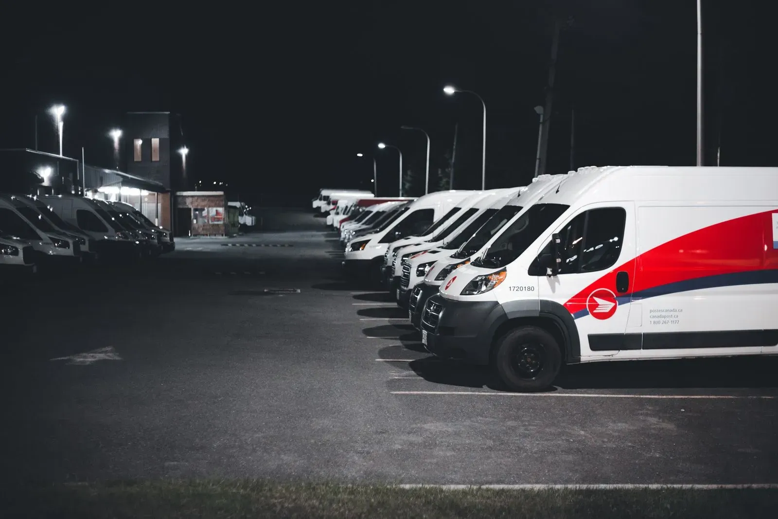 Rząd firmowych aut dostawczych na parkingu — zdjęcie poglądowe