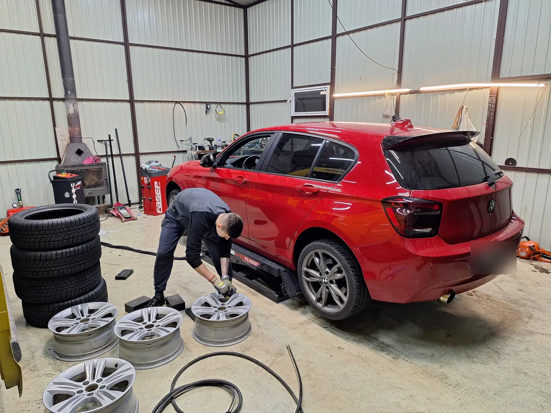 Praca przy kołach w warsztacie KB Mobile Garage — felgi aluminiowe i auto na podnośniku